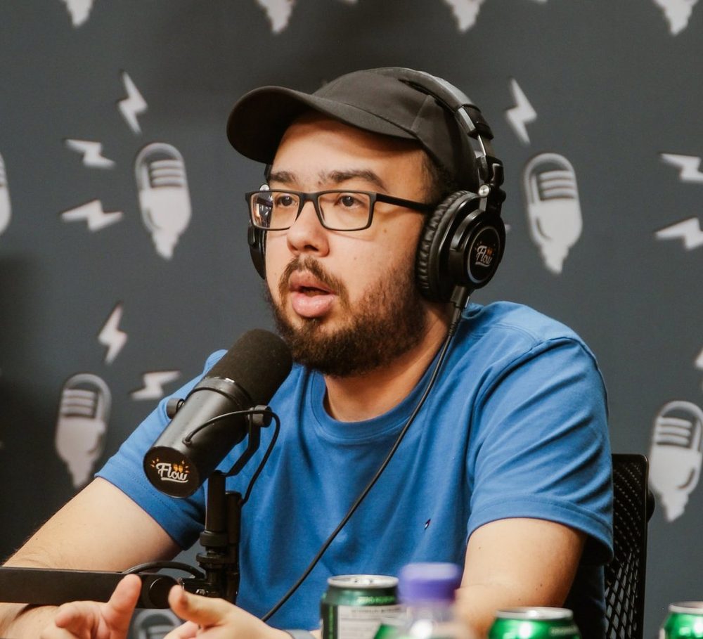 Victor Ludgero falando ao microfone em um podcast
